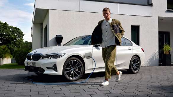 Plug-in Hybrid BMW 3er Limousine 2021 G20 Dreiviertel-Frontansicht ladend Plug-in Hybrid BMW 3er Limousine 2021 G20 Dreiviertel-Frontansicht ladend mit Model