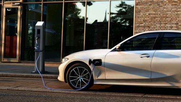 Plug-in Hybrid BMW 3er Limousine 2021 G20 Seitenansicht Plug-in Hybrid BMW 3er Limousine 2021 G20 Seitenansicht an Ladestation