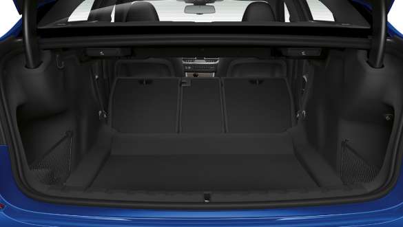 BMW 3er Limousine, Durchladesystem. Nahaufnahme des geöffnetem Kofferraums mit halb umgeklappter Rücksitzreihe.