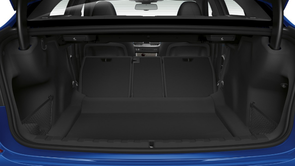 BMW 3er Limousine, Durchladesystem. Nahaufnahme des geöffnetem Kofferraums mit halb umgeklappter Rücksitzreihe.