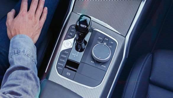 BMW 3er Limousine (G20), Steptronic Sport Getriebe. Detailaufnahme aus der Vogelperspektive von der Mittelkonsole der BMW 3er Limousine (G20) mit Schaltknauf und Steptronic Sport Getriebe.