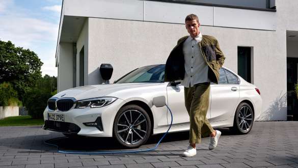 Plug-In Hybrid BMW 3er Limousine 2021 G20 Dreiviertel-Frontansicht ladend Plug-In Hybrid BMW 3er Limousine 2021 G20 Dreiviertel-Frontansicht ladend mit Model