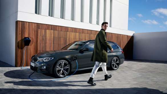 Plug-in Hybrid BMW 3er Touring 2021 G21 Dreiviertel-Seitenansicht ladend Plug-in Hybrid BMW 3er Touring 2021 G21 Dreiviertel-Seitenansicht ladend mit Model