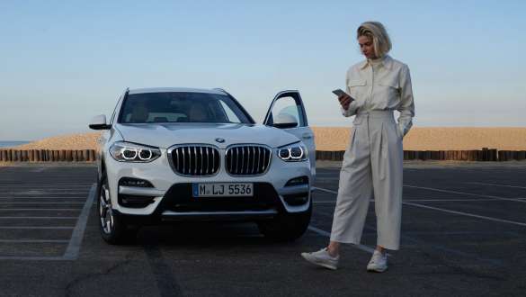 My BMW App BMW weibliches Model mit Smartphone vor BMW My BMW App BMW weibliches Model mit Smartphone vor BMW