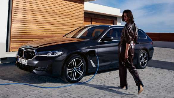 Plug-in-Hybrid BMW 5er Touring 2021 G31 LCI Dreiviertel-Seitenansicht ladend Plug-in-Hybrid BMW 5er Touring 2021 G31 LCI Dreiviertel-Seitenansicht ladend mit Model