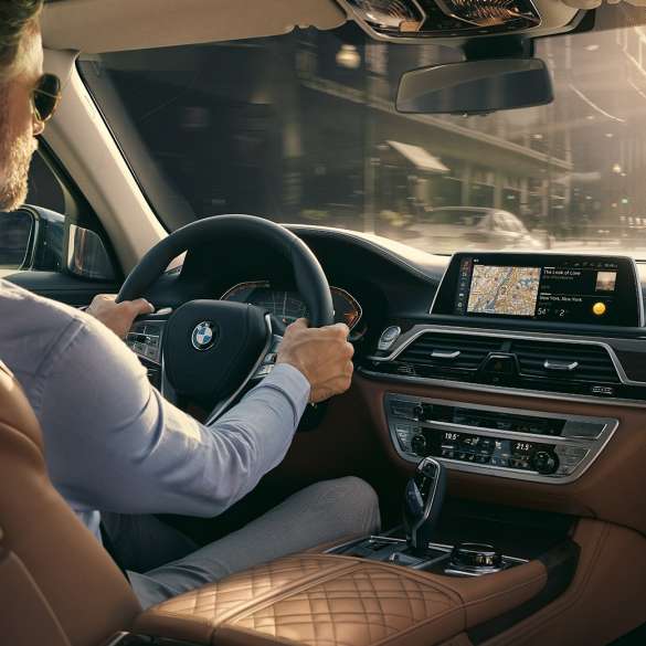 BMW 7er Limousine Connectivity Features BMW 7er Limousine: Mann sitzt im BMW und nutzt Connectivity Features