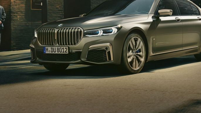 BMW M760Li xDrive in urbaner Kulisse BMW M760Li xDrive in seitlicher Frontaufnahme fährt auf Straße in urbaner Kulisse