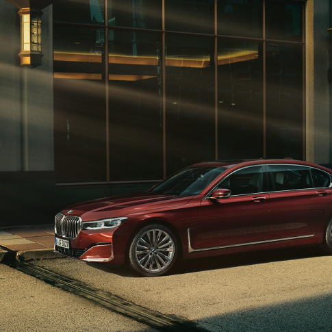 BMW Individual 7er Limousine, Seitenansicht BMW Individual 7er Limousine in rot in Seitenansicht vor urbaner Kulisse