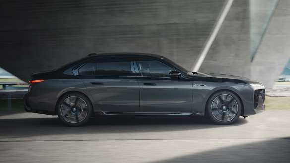 Elektrische Reichweite BMW M760e xDrive Limousine G70 M Performance Paket lektrische Reichweite BMW M760e xDrive Limousine G70 M Performance Paket BMW Individual Two-Tone Lackierung Saphirschwarz metallic BMW Individual Dravitgrau metallic Seitenansicht fahrend auf der Straße