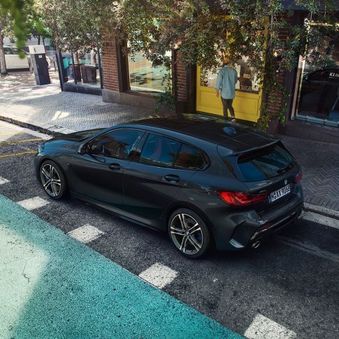 BMW M135i xDrive, parkend. BMW M135i xDrive in Saphirschwarz metallic parkend, Seitenansicht aus der Vogelperspektive.