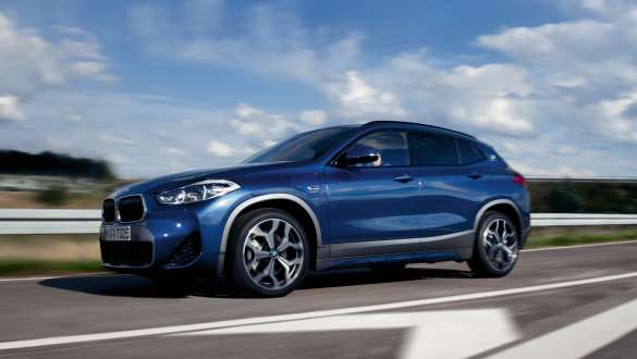 Plug-In Hybrid BMW X2 xDrive25e F39 Dreiviertel-Seitenansicht fahrend Plug-In Hybrid BMW X2 xDrive25e F39 Dreiviertel-Seitenansicht fahrend auf der Straße