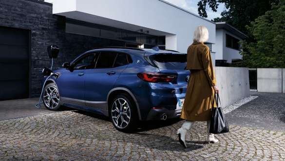 Plug-In Hybrid BMW X2 xDrive25e F39 Dreiviertel-Heckansicht ladend Plug-In Hybrid BMW X2 xDrive25e F39 Dreiviertel-Heckansicht ladend mit Model