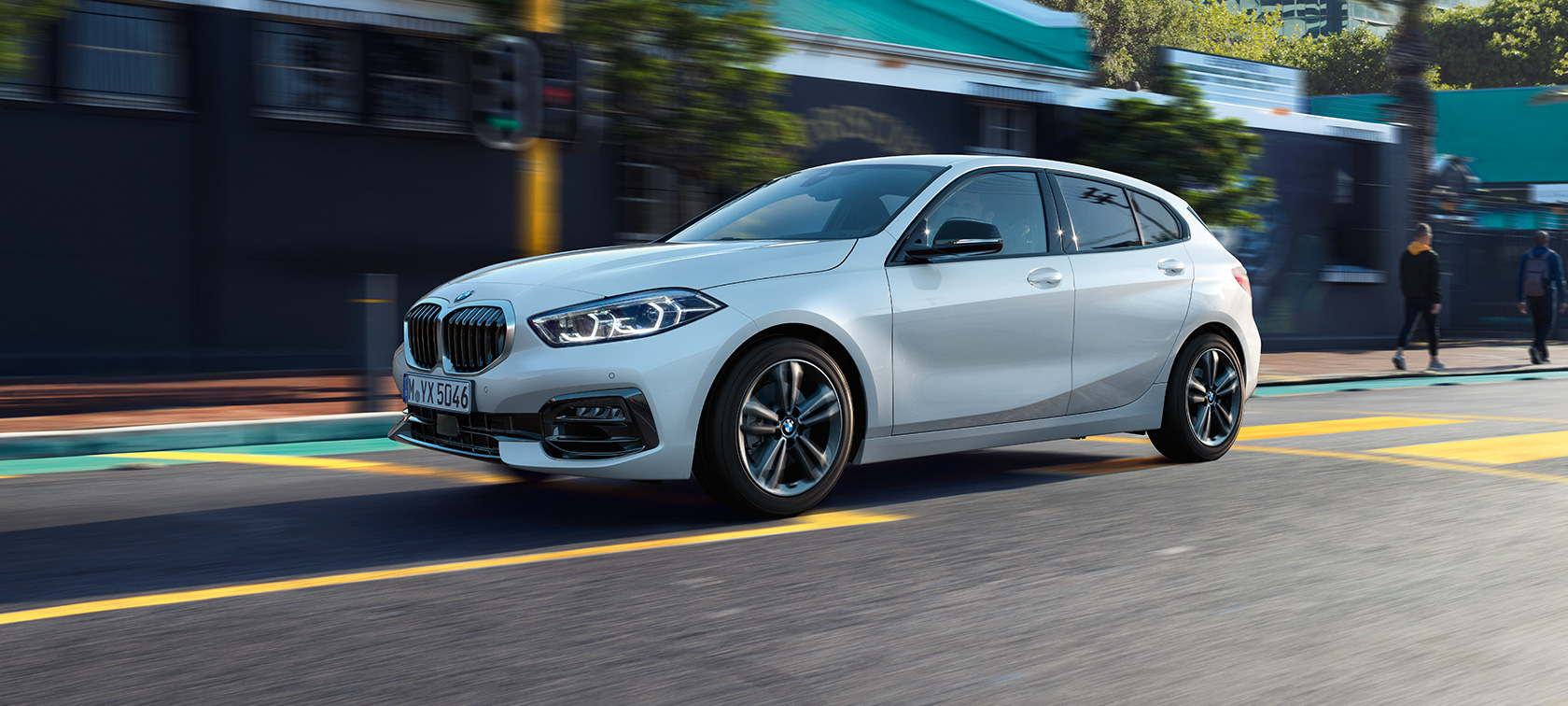 BMW 1er Modell Sport Line, Dreiviertel-Seitenansicht. BMW 1er Modell Sport Line in Mineralweiß metallic, Dreiviertel-Seitenansicht fahrend.