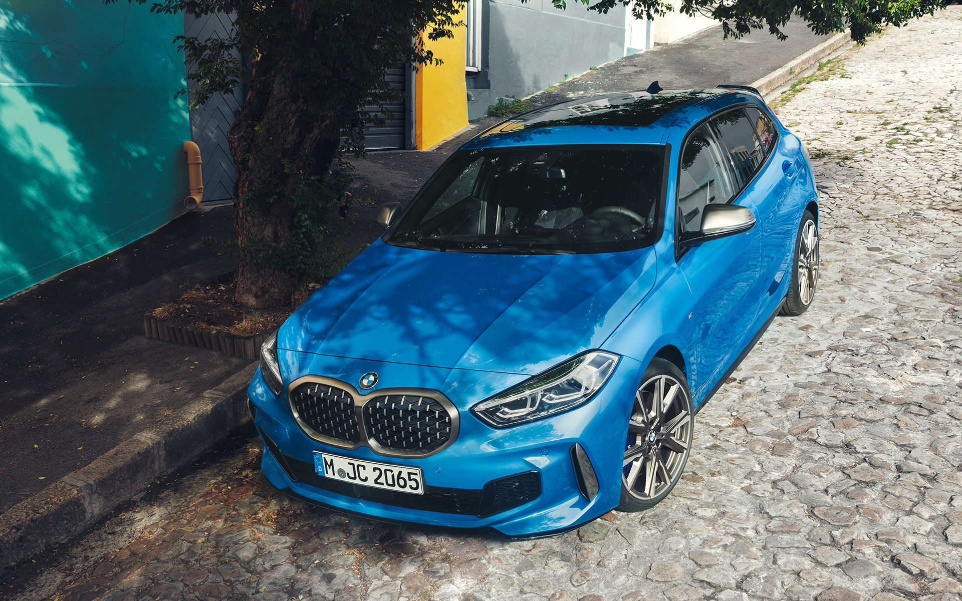 BMW 1er M135i F40 in Misano Blau metallic, Dreiviertel-Frontansicht am Straßenrand parkend aus der Vogelperspektive