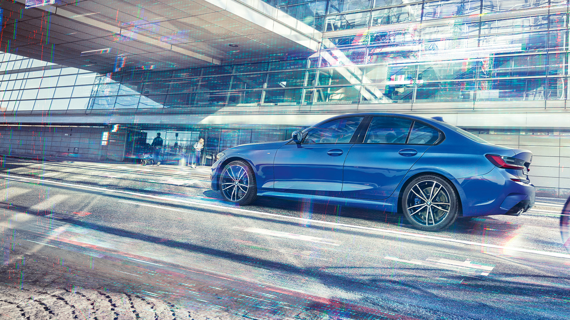 BMW 3er Limousine, Seitenansicht. Seitliche Standaufnahme der BMW 3er Limousine am Tag vor gläsernem Gebäude.