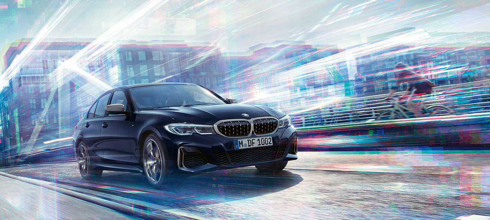 BMW 3er Limousine, BMW M340i xDrive. Dreiviertel Seitenansicht des BMW M340i xDrive bei Fahrt auf Straße vor urbaner Kulisse.