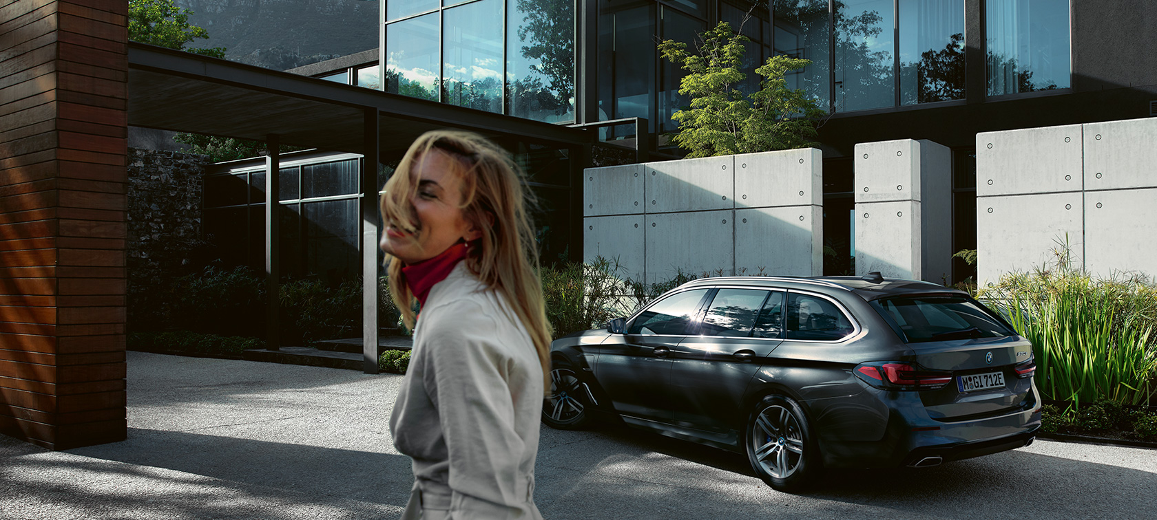 Frau vor parkendem BMW 5er Touring G31 BMW 5er Touring G31 Facelift 2020 Frau vor parkendem BMW