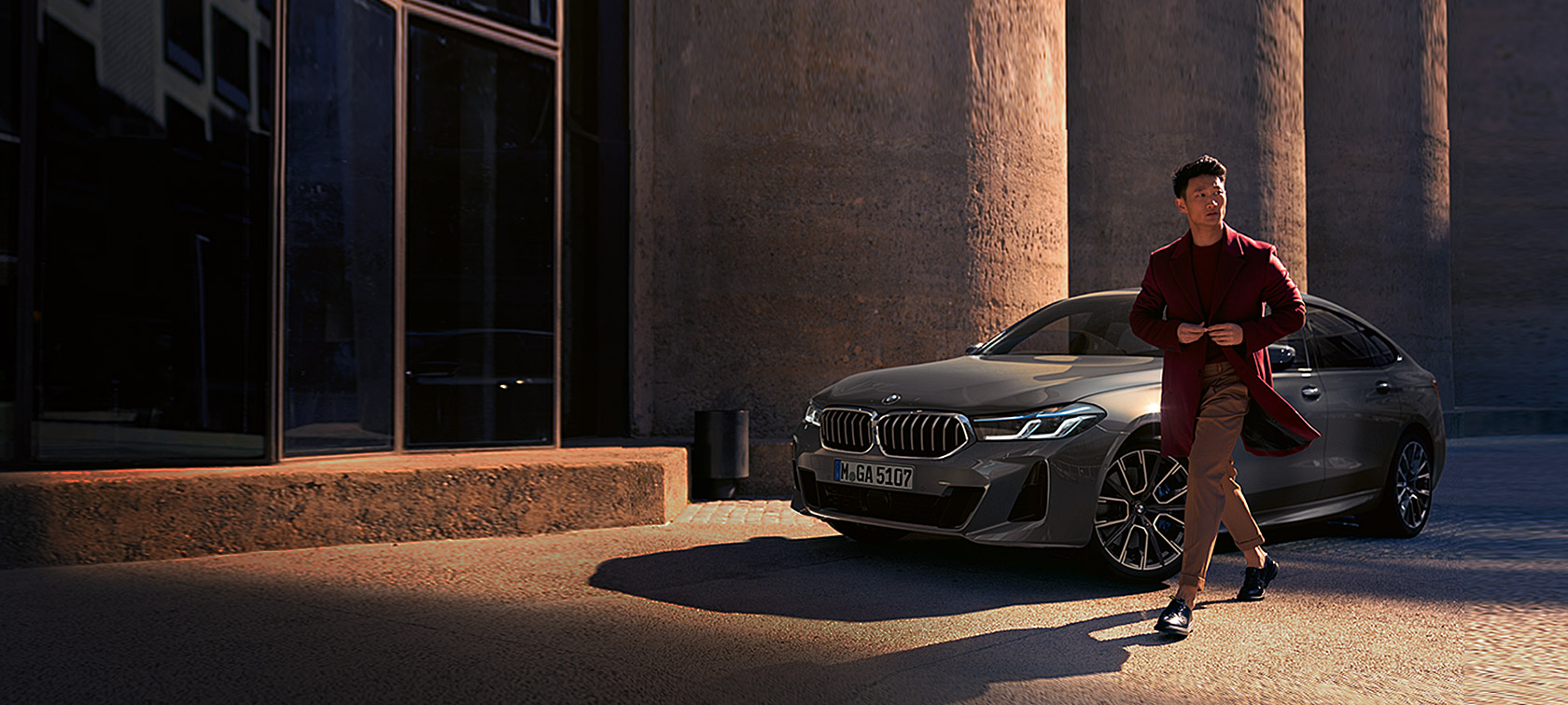 BMW 6er Gran Turismo 640i xDrive G32 2020 Berninagrau Mann vor BMW in Dreiviertel-Frontansicht stehend