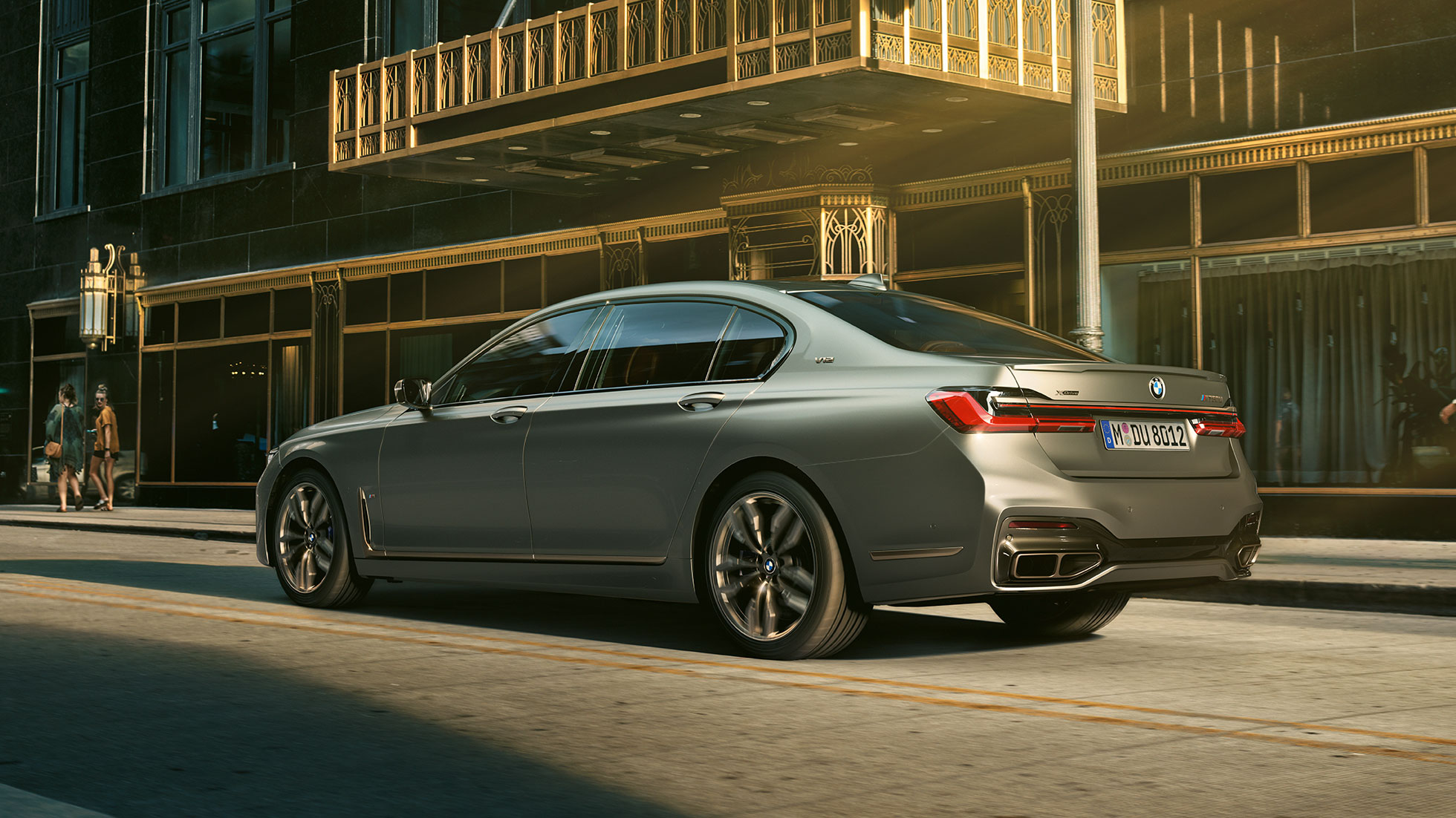 BMW M760Li xDrive mit V12-Motor BMW M760Li xDrive steht in seitlicher Heckansicht vor Wolkenkratzern in urbaner Kulisse