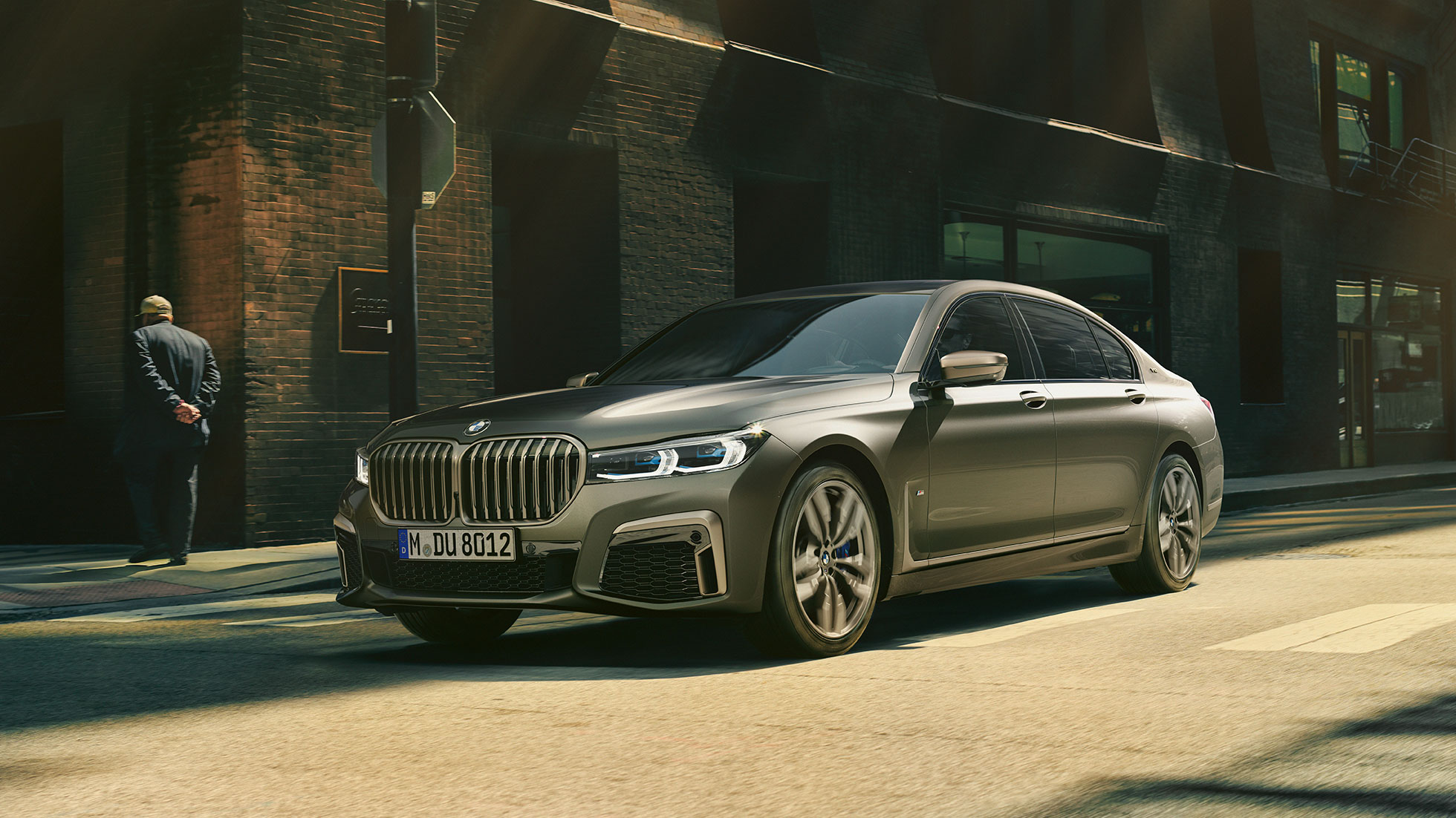 BMW M760Li xDrive in urbaner Kulisse BMW M760Li xDrive in seitlicher Frontaufnahme fährt auf Straße in urbaner Kulisse