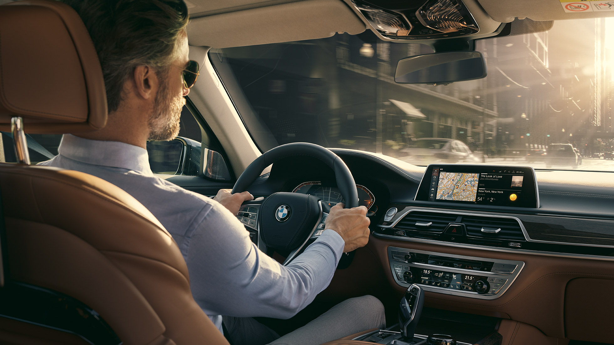 BMW 7er Limousine Connectivity Features BMW 7er Limousine: Mann sitzt im BMW und nutzt Connectivity Features