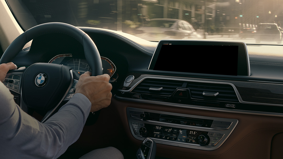 BMW Intelligent Personal Assistant BMW Intelligent Personal Assistant: Mann fährt in BMW, Nahaufnahme des Live Cockpit Professional
