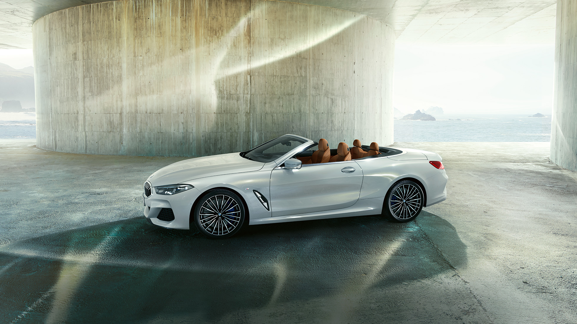 BMW M850i xDrive in Mineralweiß metallic, Seitenansicht mit geöffnetem Stoffverdeck. BMW M850i xDrive in Mineralweiß metallic, Seitenansicht mit geöffnetem Stoffverdeck.