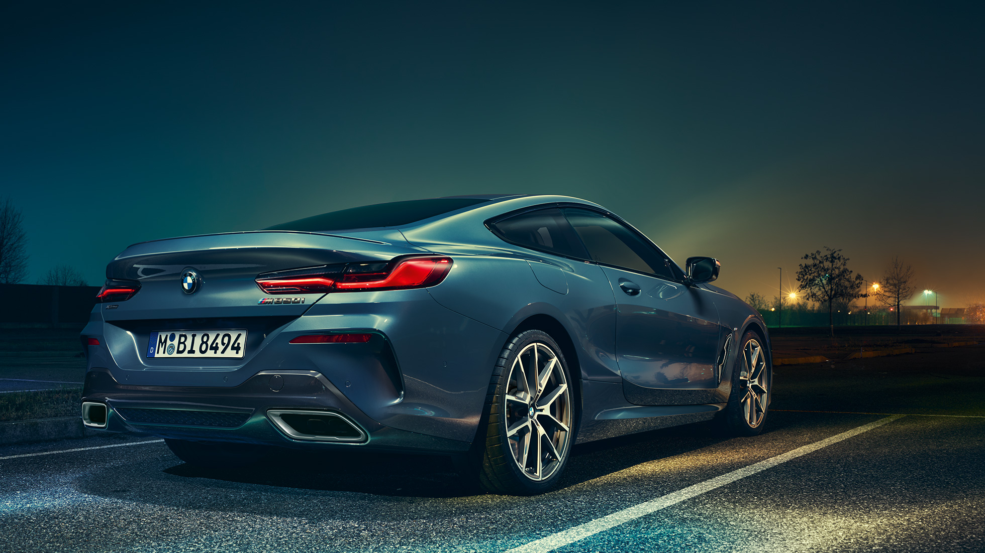 BMW 8er Coupé, Dreiviertel-Heckansicht. BMW 8er Coupé, Dreiviertel-Heckansicht, Standaufnahme vor nächtlicher Kulisse.