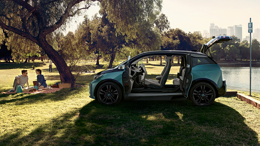 BMW i3 2018 im Park BMW i3 I01 2018 Jucarobeige mit Akzent Frozen Grey metallic Seitenansicht mit geöffneten Türen im Park