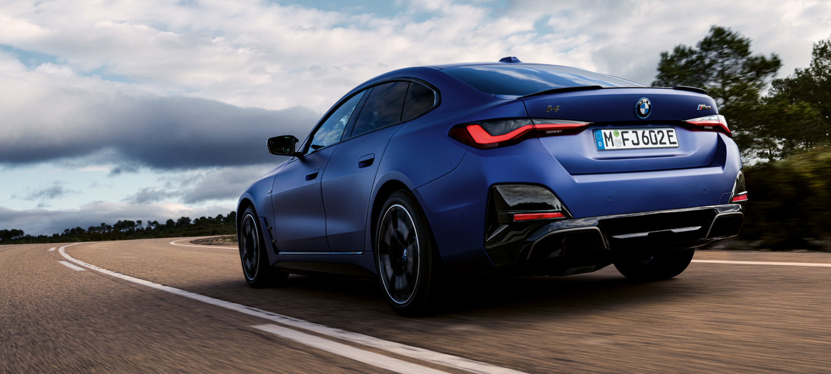 Dreiviertel-Heckansicht BMW i4 M50 G26 2021 BMW i4 M50 G26 2021 BMW Individual Frozen Portimao Blau metallic Dreiviertel-Heckansicht fahrend