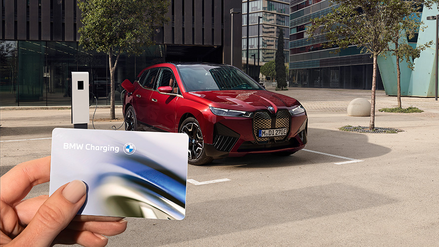 BMW iX i20 SUV Elektroauto BMW iX xDrive50 Laden BMW iX i20 2021 SUV Elektroauto BMW iX xDrive50 Aventurinrot ladend an einer öffentlichen Schnellladestation