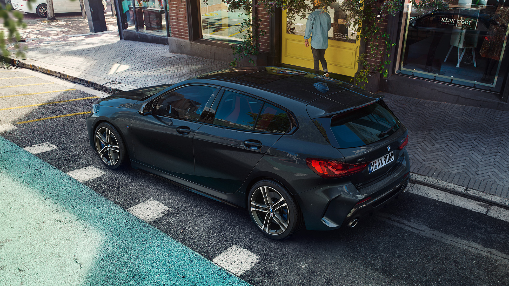 BMW M135i xDrive, parkend. BMW M135i xDrive in Saphirschwarz metallic parkend, Seitenansicht aus der Vogelperspektive.