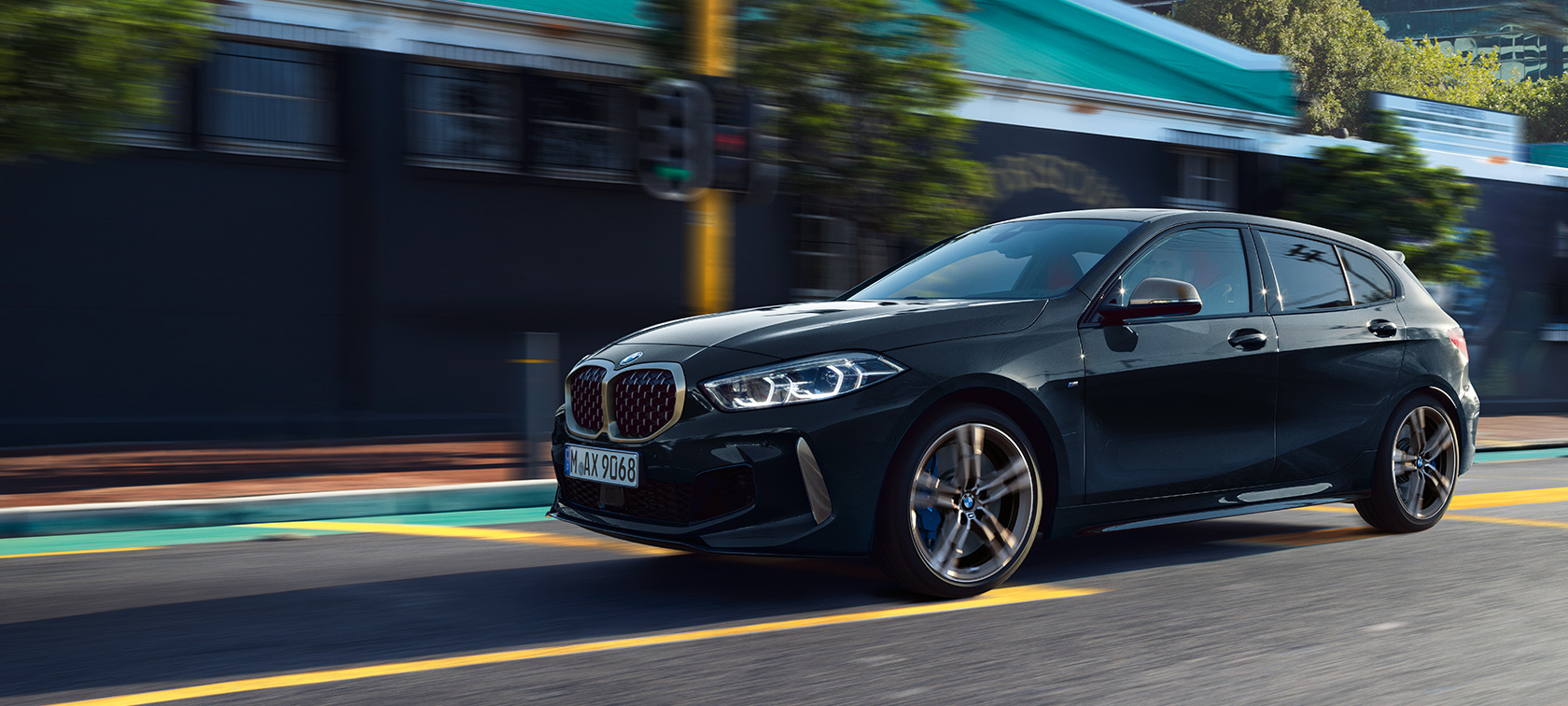 Der neue BMW M135i xDrive. Der neue BMW M135i xDrive in Saphirschwarz metallic, Dreiviertel-Seitenansicht fahrend.