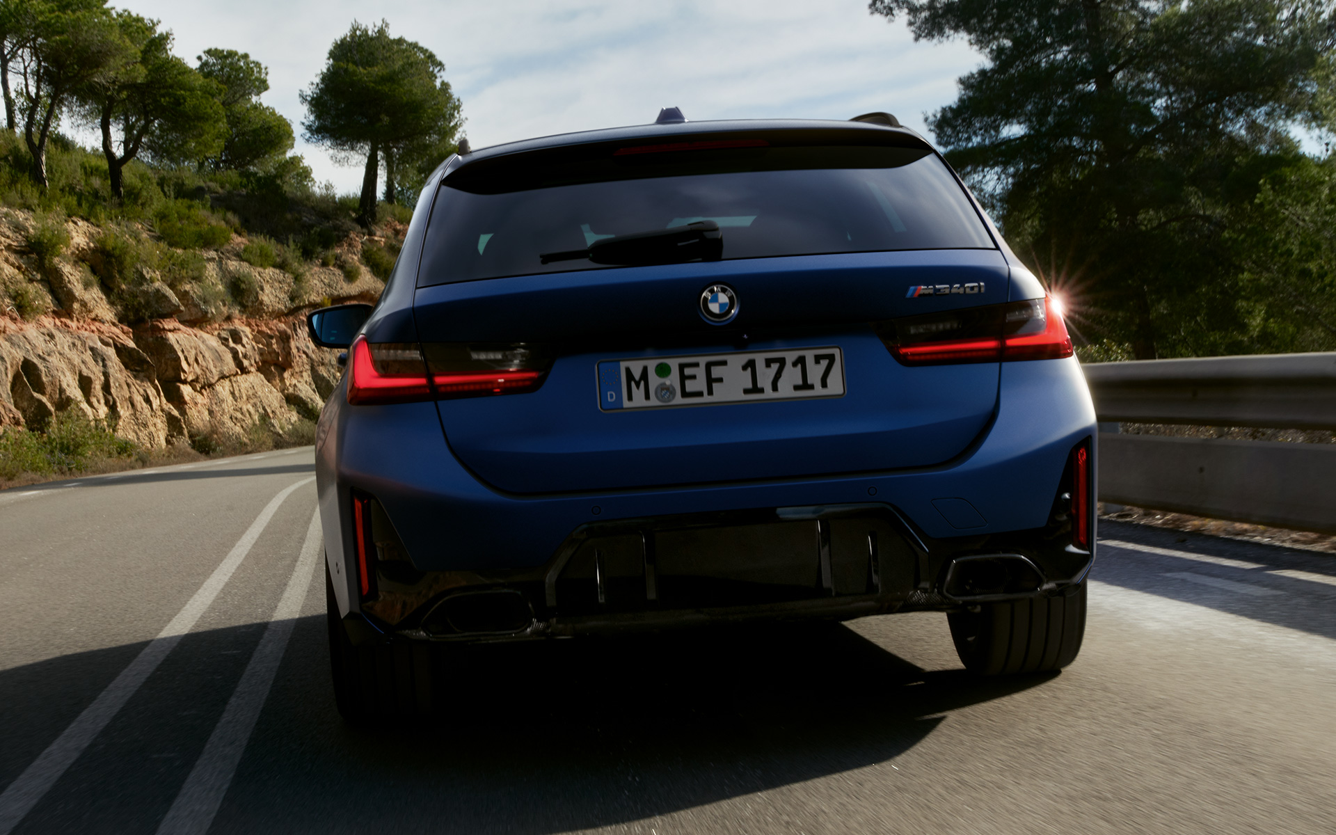 BMW M340i xDrive Touring G21 Frozen Tanzanite Blue Heckansicht fahrend auf Straße