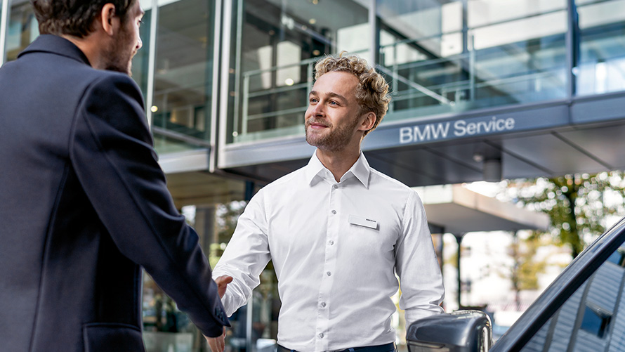 BMW Service Mitarbeiter begrüßt Kunden BMW Service Mitarbeiter begrüßt Kunden