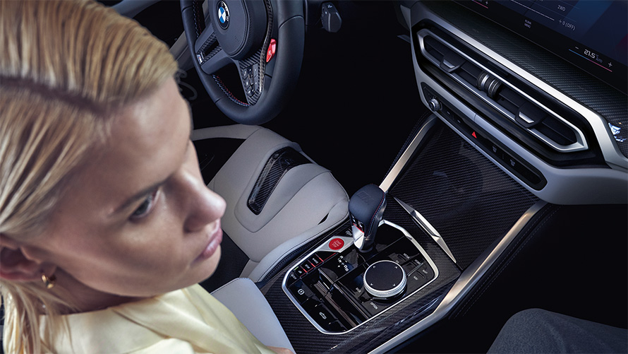 BMW M4 Competition Cabrio mit M xDrive G83 Interieur 2021 Mittelkonsole BMW M4 Competition Cabrio mit M xDrive G83 2021 Mittelkonsole und Frau auf Beifahrersitz