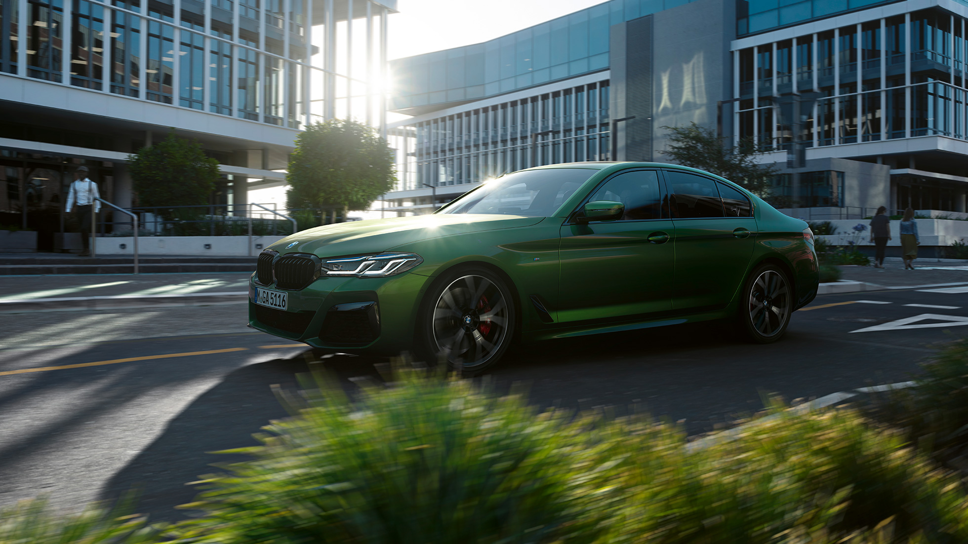 BMW M550i xDrive Limousine G30 LCI Facelift 2020 Seitenansicht fahrend BMW M550i xDrive Limousine G30 LCI Facelift 2020 BMW Individual Verde Ermes metallic Seitenansicht fahrend in der Stadt
