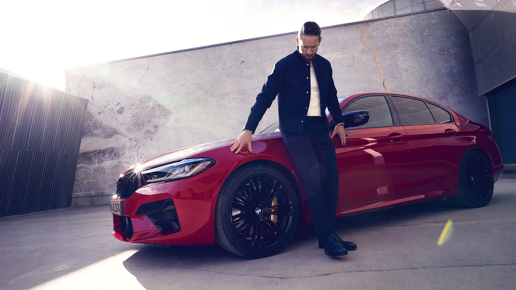 BMW M5 Competition F90 LCI Facelift 2020 Seitenansicht mit Mann BMW M5 Competition F90 LCI Facelift 2020 BMW Individual Imola Rot Seitenansicht mit Mann