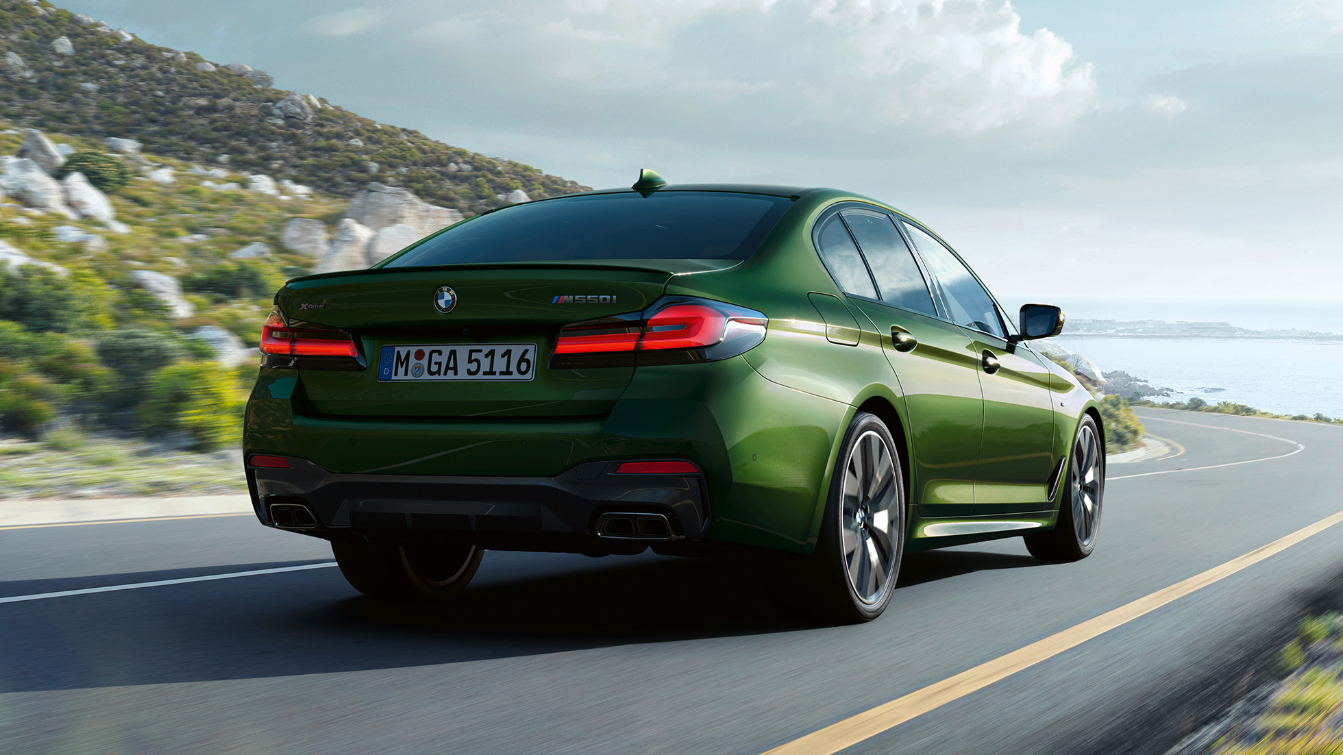 BMW M550i xDrive Limousine G30 LCI Facelift 2020 Heckansicht BMW M550i xDrive Limousine G30 LCI Facelift 2020 BMW Individual Verde Ermes metallic Heckansicht fahrend auf Landstraße