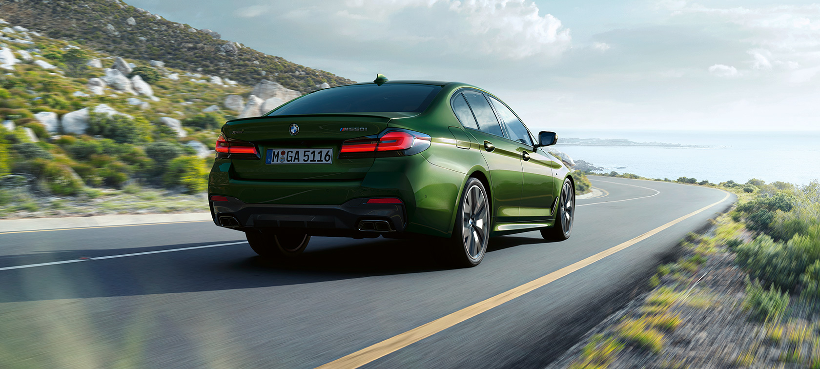 BMW M550i xDrive Limousine G30 LCI Facelift 2020 Dreiviertel-Heckansicht fahrend BMW M550i xDrive Limousine G30 LCI Facelift 2020 BMW Individual Verde Ermes metallic Dreiviertel-Heckansicht fahrend