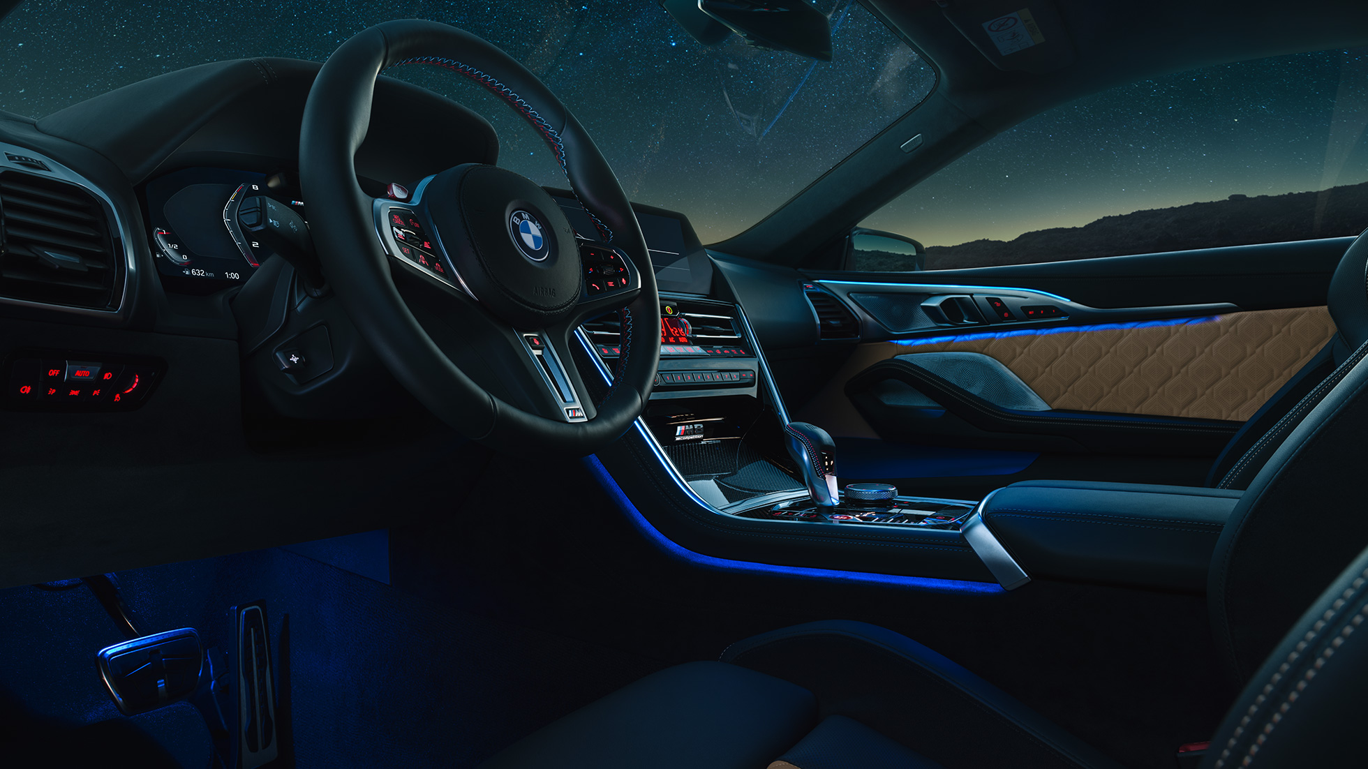 BMW M8 Competition Coupé, Cockpit. BMW M8 Competition Coupé, Cockpit bei Nacht mit M Lederlenkrad und blauem ambienten Licht.