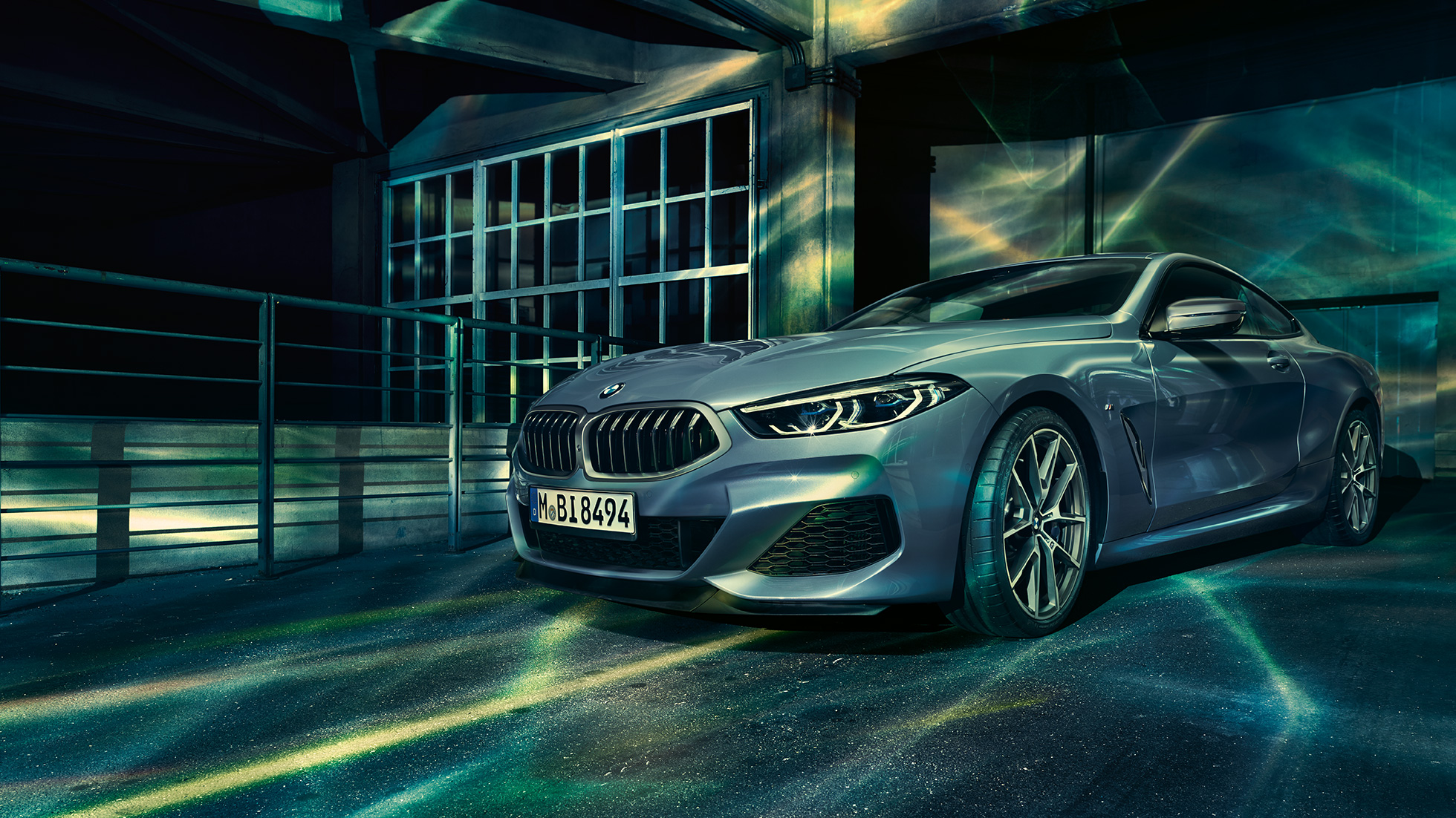 BMW M850i xDrive Coupé, Dreiviertel-Frontansicht. BMW M850i xDrive Coupé in Barcelona Blau metallic, Dreiviertel-Frontansicht stehend vor Gebäude.