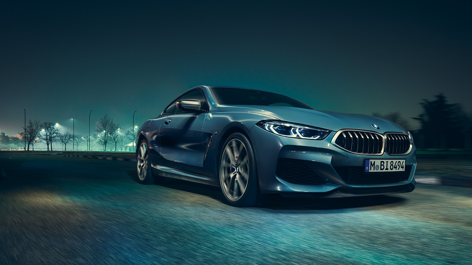 BMW M850i xDrive Coupé, Dreiviertel-Frontansicht links. BMW M850i xDrive Coupé in Barcelona Blau metallic, Dreiviertel-Frontansicht links, fahrend bei Nacht.