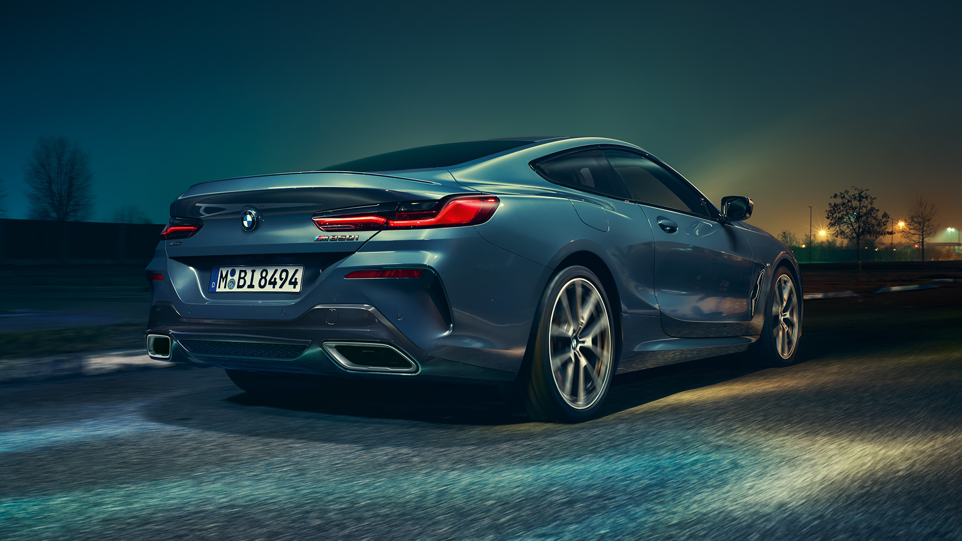BMW M850i xDrive Coupé, Heckansicht. BMW M850i xDrive Coupé in Barcelona Blau metallic, Heckansicht, fahrend bei Nacht.