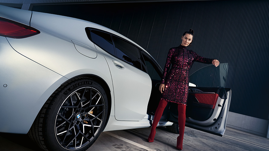 BMW M8 Competition Gran Coupé F93 LCI Facelift 2022 BMW Individual Frozen Brilliant White metallic Dreiviertel-Heckansicht mit Model Froschperspektive