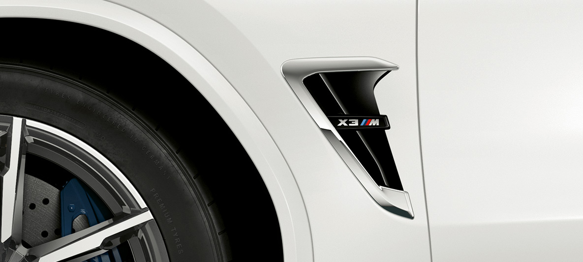 BMW X3 M, M Kieme. BMW X3 M in Alpinweiß, Exterieur, M Kieme mit Chrom-Highlights und Modellkennzeichnung.