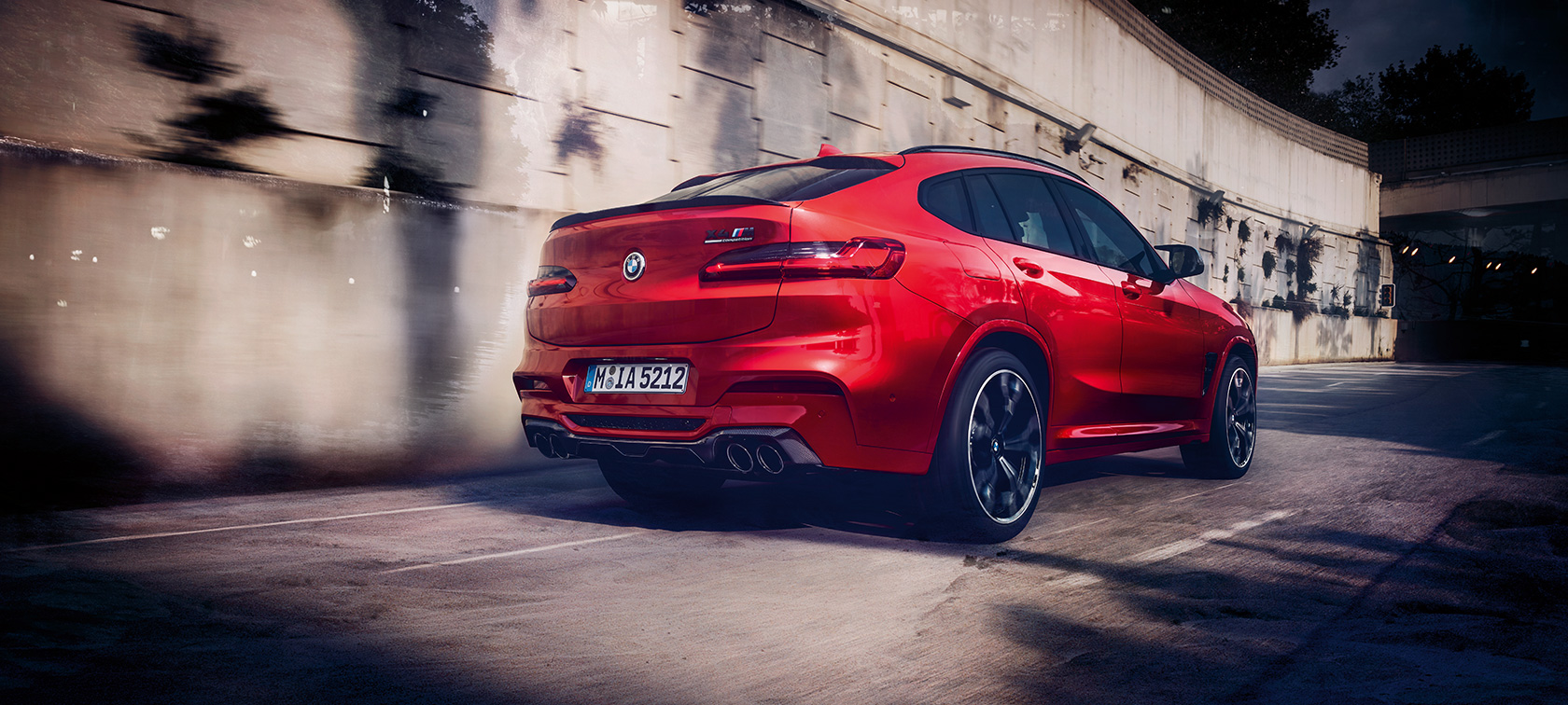 BMW X4 M Competition, Dreiviertel-Heckansicht. BMW X4 M Competition in Toronto Rot metallic, fahrend, Exterieur, Dreiviertel-Heckansicht.