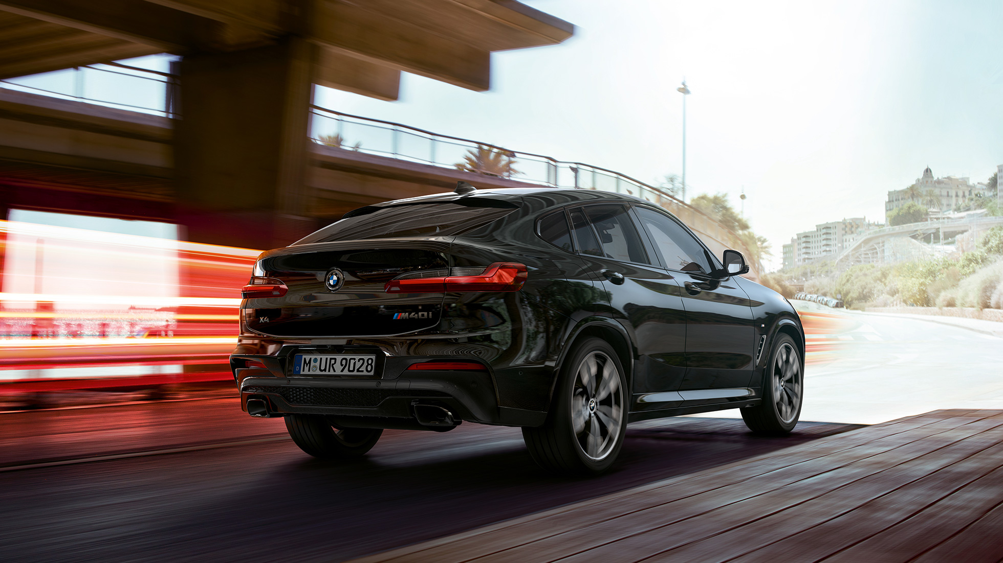 BMW X4 M40i, Dreiviertel-Frontansicht. BMW X4 M40i in Saphierschwarz metallic, fahrend, Exterieur, Dreiviertel-Frontansicht mit Lichtstreifen.