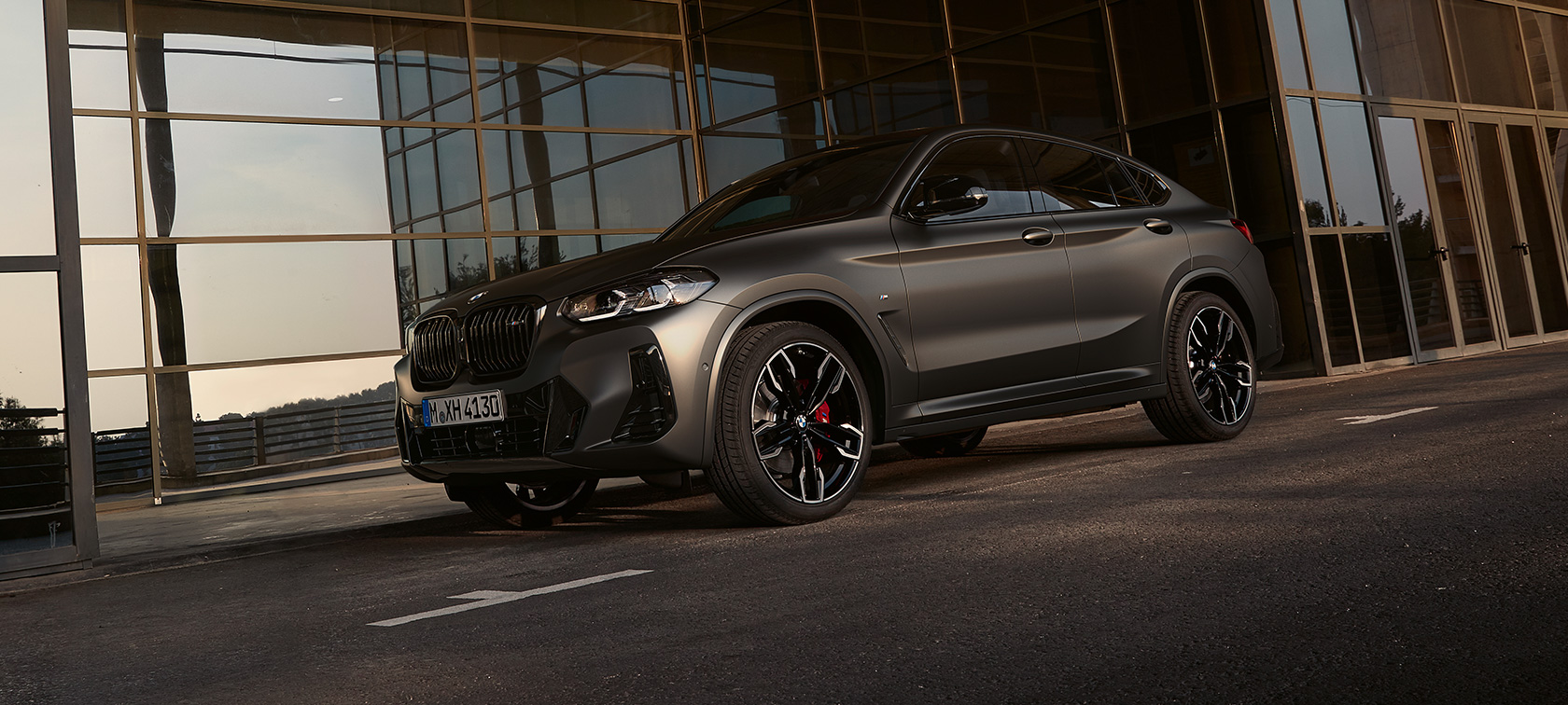 Dreiviertel-Frontansicht BMW X4 M40i G02 LCI 2021 Facelift BMW X4 M40i G02 LCI 2021 Facelift Dreiviertel-Frontansicht vor Glasfassade