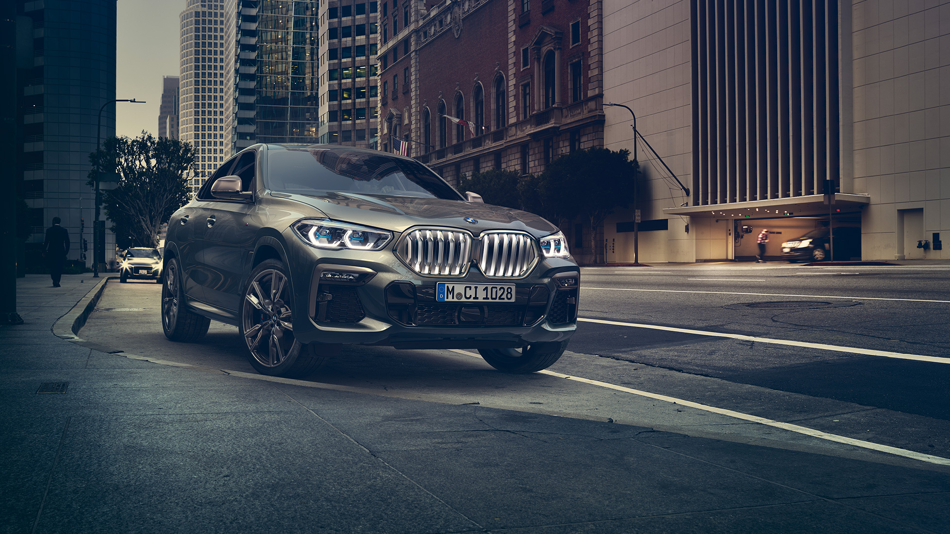BMW X6 M50i stehend BMW X6 M50i in Dreiviertel-Frontperspektive stehend vor urbaner Kulisse